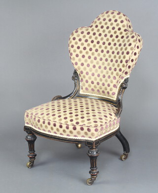A Victorian ebonised show frame nursing chair, seat and back upholstered in polkadot material, raised on cabriole supports, brass caps and casters 87cm h x 57cm w x 50cm d (seat 39cm x 40cm) 