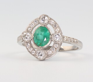A white metal, stamped Plat, Edwardian style oval emerald and diamond ring, emerald 0.8ct, brilliant cut diamonds 0.3ct, size M, 4gms