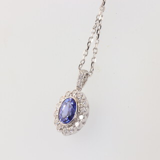 A white metal, stamped 18ct, oval tanzanite and diamond pendant, oval tanzanite 1.53ct, the diamonds 0.61ct hun on an 18ct 44cm chain, 4.9gms