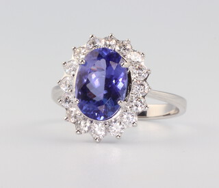 A white metal, stamped 750, oval tanzanite and diamond cluster ring, the centre stone 2.19cts, the sixteen brilliant cut diamonds 0.65ct, size K, 2.8gms