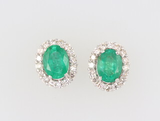 A pair of white metal 18ct, oval emerald and diamond ear studs, the emeralds 2.53ct and the 10 brilliant cut diamonds 0.74ct, 42gms