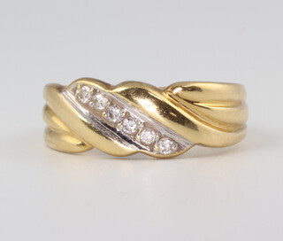 A yellow metal diamond set crossover ring, size M, 3.7gms