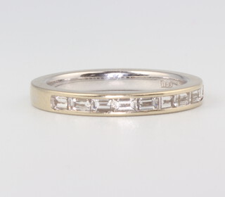 An 18ct white gold baguette cut diamond half eternity ring, size J 1/2, 3.5gms