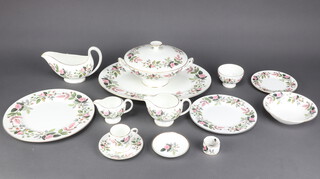 A Wedgwood Hathaway Rose coffee and dinner service comprising 8 coffee cans, 8 saucers, cream jug, milk jug, sugar bowl, 9 small plates, 7 medium plates, 8 dinner plates, an oval meat plate, 8 dessert bowls, 2 tureens and covers, a sauceboat and stand, an oval dish, 2 circular dishes, 2 napkin rings