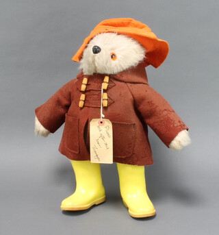A Gabrielle Designs Paddington bear with duffle coat, label and yellow Dunlop wellingtons