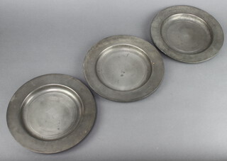 Three 18th/19th Century circular pewter plates, the reverse with touchmark 23cm diam