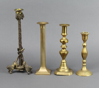 A 19th Century gilt bronze candlestick supported by three lions 32cm h x 12 cm diam, a 19th Century brass candlestick with with knop stem and ejector 25cm h x 9cm w x 8cm d, a brass reeded candlestick raised on a square base 26cm h x 7cm w x 7cm d and one other candlestick 21cm h x 8cm