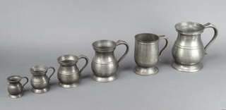 A set of five graduated baluster shaped pewter tankards and a pewter pint tankard