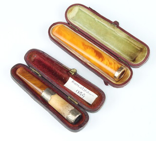 A yellow metal mounted amber cigar holder, cased, a silver mounted ditto Birmingham 1899 