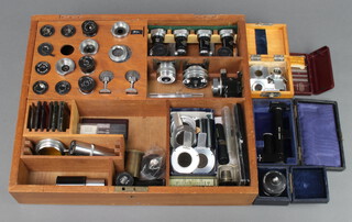 A wooden tray containing various microscope lenses etc