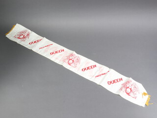 A Queen concert banner from the 1979 Crazy Tour, white nylon, red lettering with gold tassels, 14cm h x 109cm l. Purchased by the vendor at the Purley Roxy where Queen performed in December 1979.