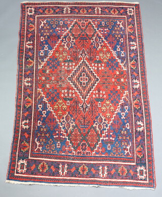 A red, blue and orange ground Afghan rug with central medallion within a multi row border (in wear) 202cm h x 128cm 