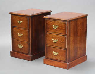 A pair of oak bedside chests of 3 drawers, raised on platform base with brass swan neck drop handles 63cm h x 39cm w x 48cm d 