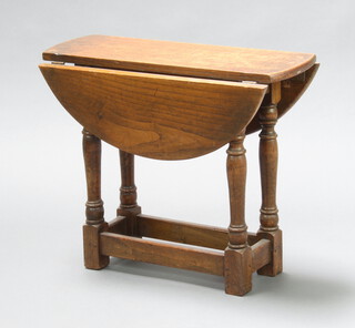 An oak utility oval drop flap tea table raised on turned and block supports 50cm h x 60cm w x 21cm when closed x 59cm when open, base marked CC41 4728F201  