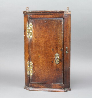 A 17th/18th Century oak hanging corner cabinet fitted shelves enclosed by a panelled door 46cm h x 26cm w x 16cm d 