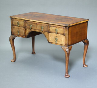 A Queen Anne style crossbanded walnut writing table fitted a drawer flanked by 4 short drawers, raised on cabriole supports 77cm h x 113cm w x 56cm d 