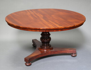 A Victorian circular mahogany snap top breakfast table raised on a turned column and tripod base on bun feet 73cm h x 138cm diam. 