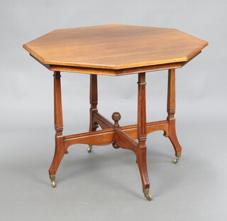 An Edwardian octagonal mahogany occasional table raised on outswept supports, brass caps and casters 74cm h x 91cm w x 90cm (split to top, scratched and pitted) 