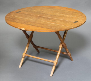 Thornton and Herne, a 19th/20th Century circular pine folding coaching table raised on turned supports 61cm h x 96cm diam. (some splits to the top)