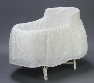 An oval white painted wicker crib with white Harrods counterpane 85cm h x 100cm w x 54cm d
