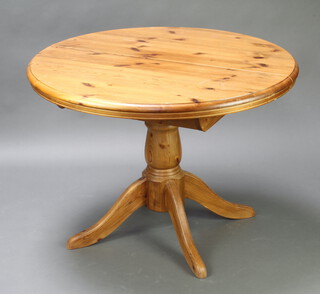 A circular pine pedestal dining table, raised on a turned column and tripod base 76cm h x 107cm diam. (contact marks to the top) 