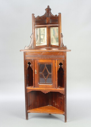 An Edwardian walnut corner cabinet, the raised back fitted a shelf above mirrored panels, the base fitted a cupboard flanked by recesses above a recess 145cm h x 64cm w x 47cm d (top missing a finial and is loose)  
