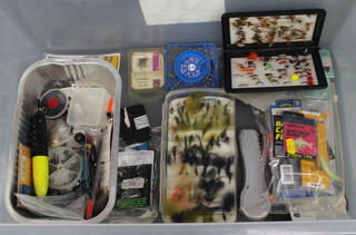A back plastic box containing a collection of fishing flies, a transparent ditto and various fishing weights etc 