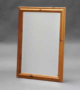 A rectangular bevelled plate mirror contained in a pine frame 88cm h x 62cm 