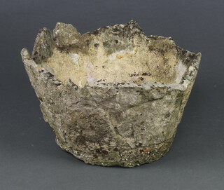 A circular well weathered concrete garden urn with wavy border 23cm x 40cm diam. 