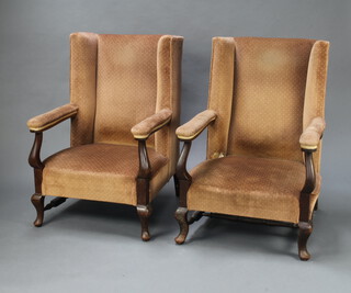 A pair of 1930's Georgian style beech framed winged open arm chairs upholstered in brown material, on turned supports 97cm h x 70cm w x 71cm d (38cm x 38cm, stain to seat, stretcher missing) 