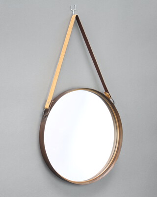 A circular plate mirror contained in a copper frame hung from a leather strap 40cm diam. 