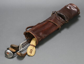 A vintage leather golf bag containing 4 drivers and 2 irons 