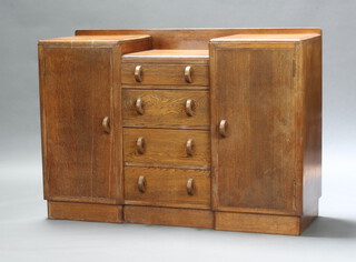 A 1930's Art Deco oak drop pedestal sideboard with raised back, the centre fitted 4 drawers flanked by a pair of cupboards 98cm h x 138cm w x 47cm d