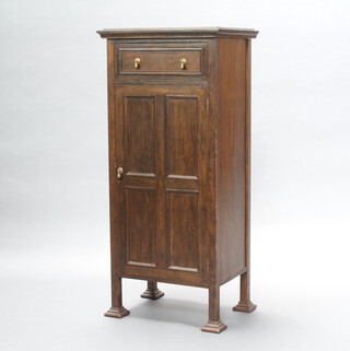 An Art Nouveau, Liberty style, oak music cabinet fitted a drawer above cupboard enclosed by a panelled door 123cm h x 56cm w x 41cm d 
