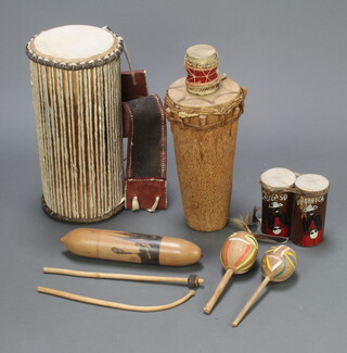 A Nigerian double sided drum 50cm x 25cm, 1 other 40cm x 19cm, a smaller drum 10cm x 7cm, pair of maracas etc