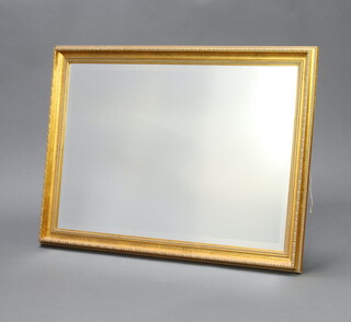 A rectangular bevelled plate wall mirror contained in a decorative gilt frame 73cm x 103cm 