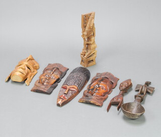 Four carved hardwood masks, a carved figure of a standing mythical gentleman 39cm x 9cm x 6cm, carved stone and 1 other carved item 