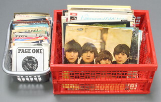 A collection of 1960/70's vinyl LP album records including Sargent Peppers Lonely Heart Club Band, Rubber Soul, Beatles for Sale, Beatles in Abbey Road and other records, contained in a red plastic crate together with a collection of 45 records contained in a grey plastic crate 
