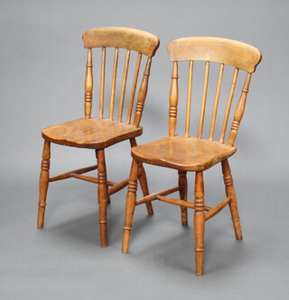 A pair of 19th Century elm Windsor style stick and rail back kitchen chairs with solid seat, raised on turned supports with H framed stretcher 85cm h x 35cm w x 36cm d, backs marked J H & S
