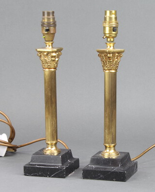 A pair of gilt metal and black onyx table lamps in the form of Corinthian columns raised on square bases 34cm x 9cm x 9cm 