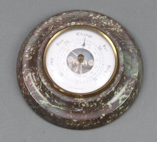 An aneroid barometer with silvered dial contained in a circular carved serpentine case 16cm 