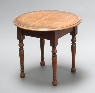 A 1930's circular oak occasional table raised on turned supports 51cm x 60cm (ring and water marks, sun bleached to top)