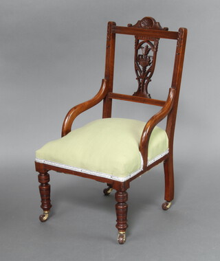 A Victorian carved and pierced walnut slat back nursing chair with overstuffed seat upholstered in green material, raised on turned supports 83cm h x 45cm w x 43cm d (seat 21cm x 30cm) 