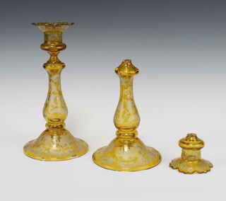 A pair of 19th Century Bohemian amber flash glass candlesticks decorated with scrolls, flowers and buildings 26cm (1 is broken, the other is chipped) 