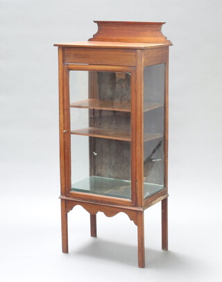 An Edwardian inlaid mahogany display cabinet with raised back fitted shelves enclosed by glazed panelled doors, raised on square tapered supports 132cm h x 56cm w x 36cm d 