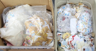 A quantity of used GB stamps, some on paper, contained in a grey crate and pickfords box