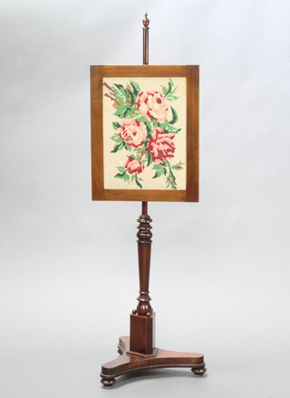 A Victorian mahogany pole screen with rectangular Berlin woolwork banner raised on a turned column and triform base 131cm h x 37cm x 36cm 