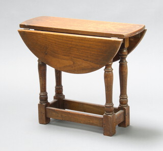 An oak utility oval drop flap tea table raised on turned and block supports 50cm h x 60cm w x 21cm when closed x 59cm when open, base marked CC41 4728F201  (contact marks)