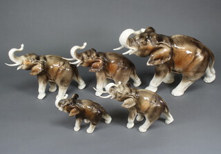 A herd of 5 Royal Dux elephants 33cm (broken tusk and cracked), 26cm (broken tusk and cracked), 26cm (broken tusk), 20cm (replaced tusks) and 16cm (broken tusks) 
