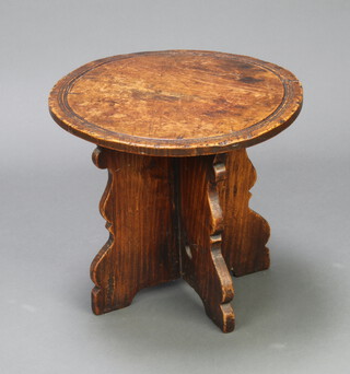 A circular carved elm occasional table raised on X framed supports 40cm h x 45cm diam., (top is warped, slight scratches) 
